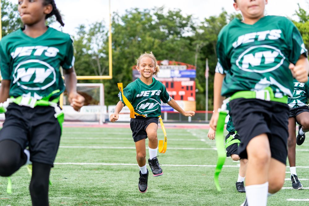 Young flag football players running drills
